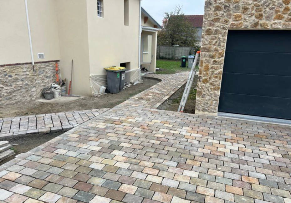 Cour pavée aménagée devant un garage dans l'Essonne (91)