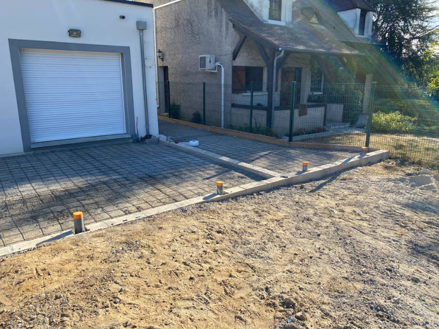 gros plan sur des aménagements extérieurs création d'allées decvant une porte de garage